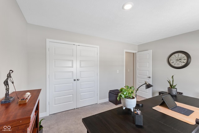 carpeted office space with a textured ceiling