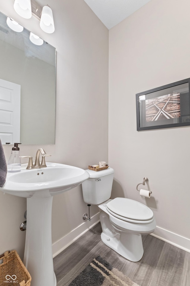 bathroom featuring sink, wood-type flooring, and toilet