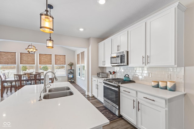 kitchen with white cabinetry, appliances with stainless steel finishes, sink, and hanging light fixtures