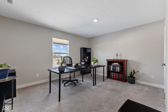 home office with light colored carpet and a textured ceiling