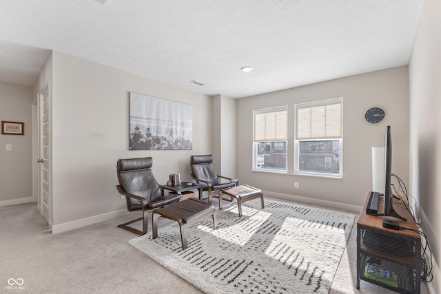 living area featuring light carpet and a textured ceiling