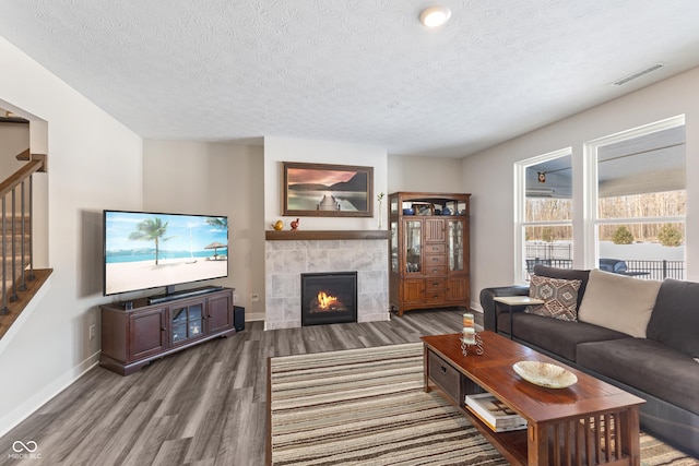 living room featuring hardwood / wood-style floors, a fireplace, and a textured ceiling