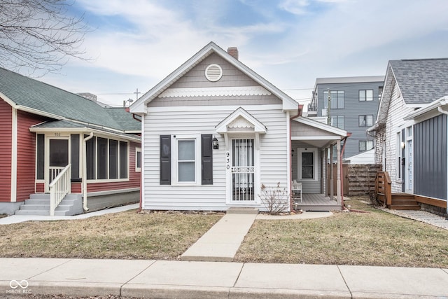 view of front of home with a front yard and a sunroom