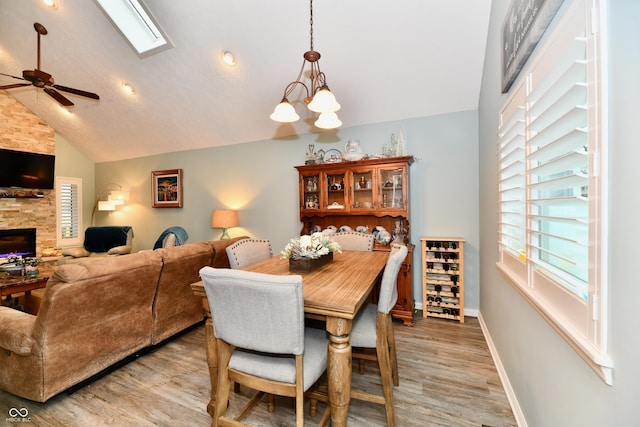 11710 E 75th St, Indianapolis, IN 46236 - dining space with high vaulted ceiling, a fireplace, ceiling fan with notable chandelier, and light hardwood / wood-style flooring