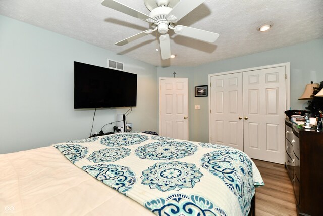 11710 E 75th St, Indianapolis, IN 46236 - bedroom featuring ceiling fan, wood-type flooring, a closet, and a textured ceiling