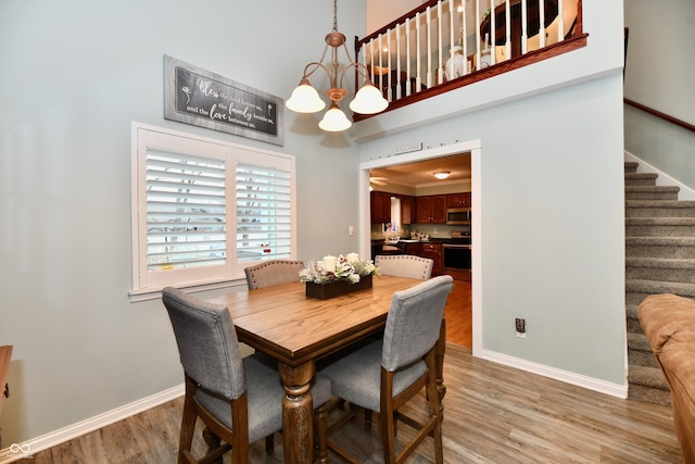 11710 E 75th St, Indianapolis, IN 46236 - dining room featuring an inviting chandelier, a towering ceiling, and light hardwood / wood-style flooring