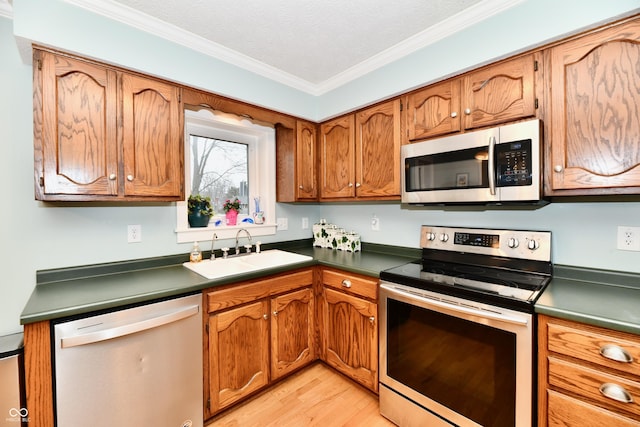 11710 E 75th St, Indianapolis, IN 46236 - kitchen featuring appliances with stainless steel finishes, sink, light wood-type flooring, crown molding, and a textured ceiling