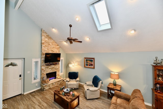 11710 E 75th St, Indianapolis, IN 46236 - living room featuring a skylight, high vaulted ceiling, light wood-type flooring, ceiling fan, and a fireplace