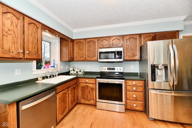 11710 E 75th St, Indianapolis, IN 46236 - kitchen featuring sink, appliances with stainless steel finishes, ornamental molding, light hardwood / wood-style floors, and a textured ceiling