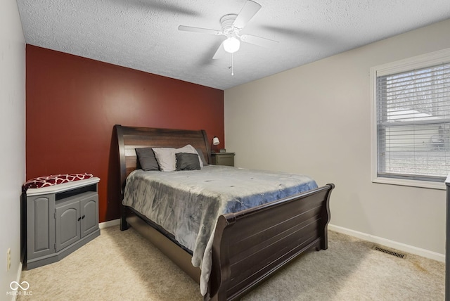 carpeted bedroom with ceiling fan and a textured ceiling