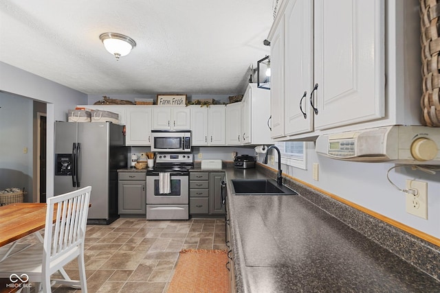 kitchen with white cabinetry, appliances with stainless steel finishes, sink, and a textured ceiling