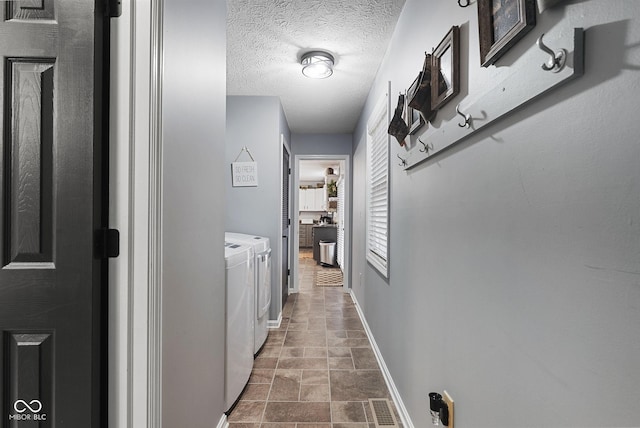 corridor featuring washing machine and dryer and a textured ceiling