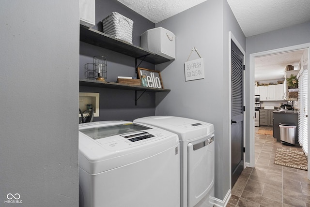 clothes washing area featuring a textured ceiling and independent washer and dryer