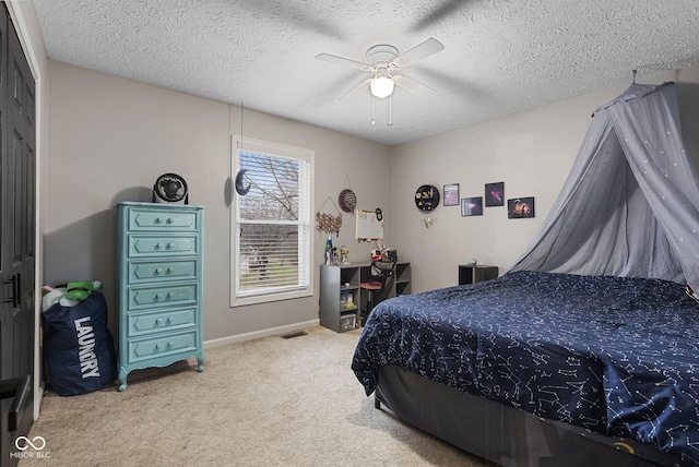 carpeted bedroom with ceiling fan and a textured ceiling