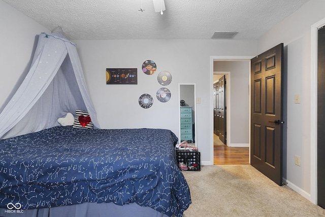 bedroom featuring ceiling fan, carpet flooring, and a textured ceiling