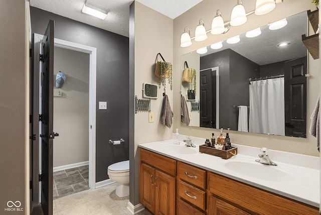 bathroom featuring vanity, a textured ceiling, and toilet