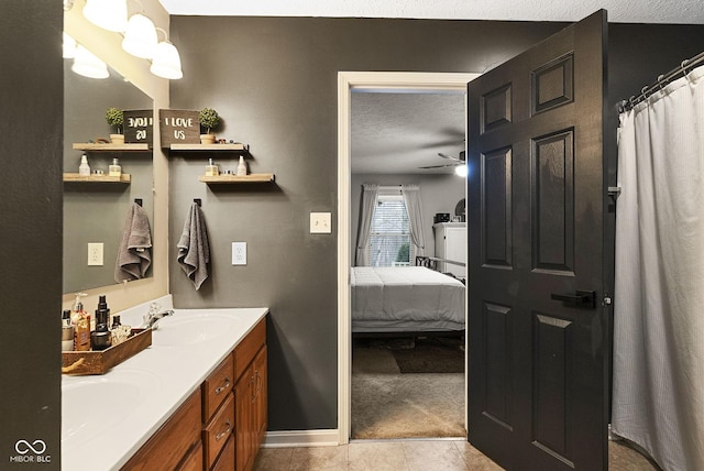 bathroom with ceiling fan, vanity, tile patterned flooring, and a textured ceiling