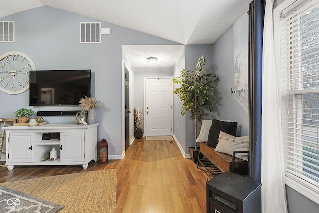 entrance foyer featuring lofted ceiling and light hardwood / wood-style floors