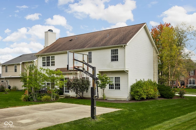 back of property with a lawn and a patio