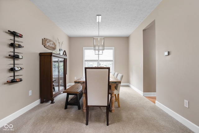 dining room with light carpet and a textured ceiling