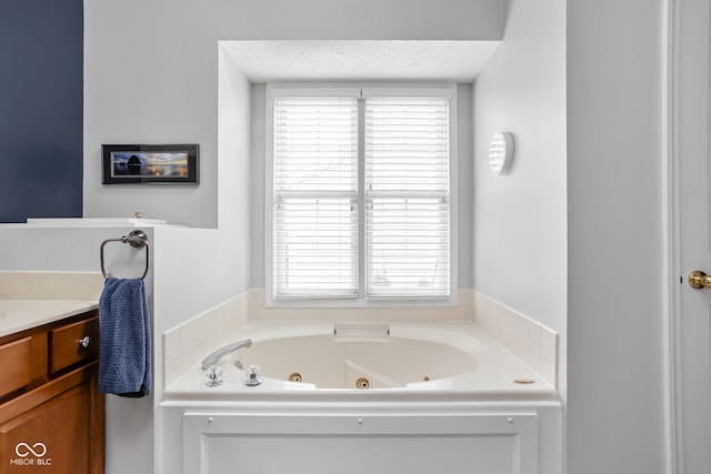 bathroom featuring vanity, a tub, and a textured ceiling