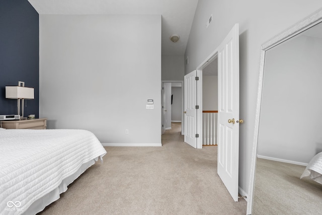 bedroom featuring light carpet and a high ceiling