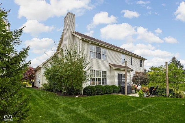 rear view of house with a yard and a patio