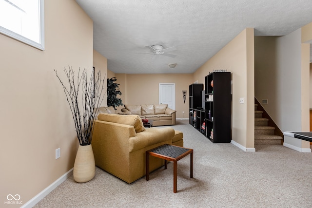 carpeted living room with ceiling fan and a textured ceiling