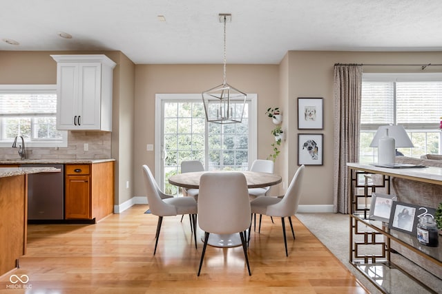 dining space featuring sink, light hardwood / wood-style floors, and a textured ceiling