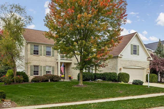 view of front facade featuring a balcony, a garage, and a front yard