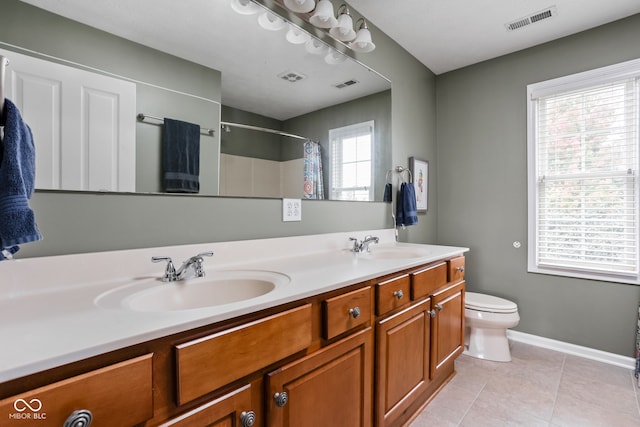 bathroom with vanity, walk in shower, tile patterned floors, and toilet