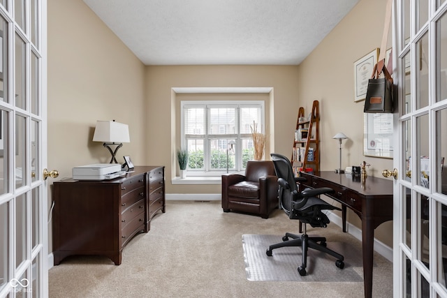 carpeted home office with french doors and a textured ceiling