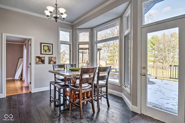 dining space featuring baseboards, a chandelier, dark wood-type flooring, and crown molding