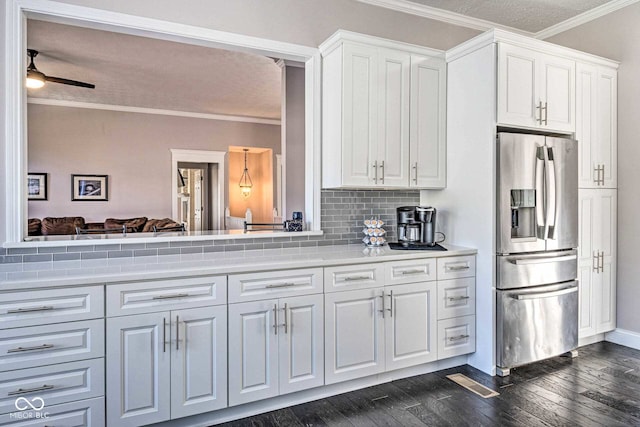 kitchen with dark wood-style floors, light countertops, ornamental molding, and stainless steel fridge with ice dispenser