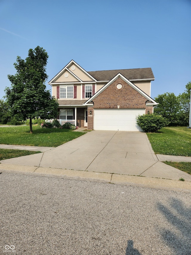 traditional-style home with driveway, a front yard, a garage, and brick siding