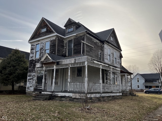 victorian-style house with a front yard and a porch