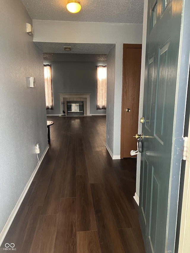 corridor with dark wood-type flooring and a textured ceiling