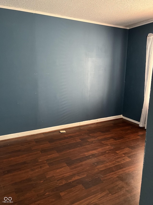 empty room with ornamental molding, a textured ceiling, and dark hardwood / wood-style flooring