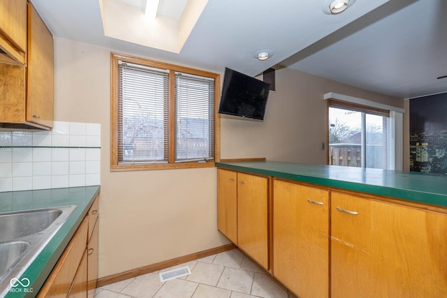 kitchen featuring sink, decorative backsplash, and light tile patterned floors