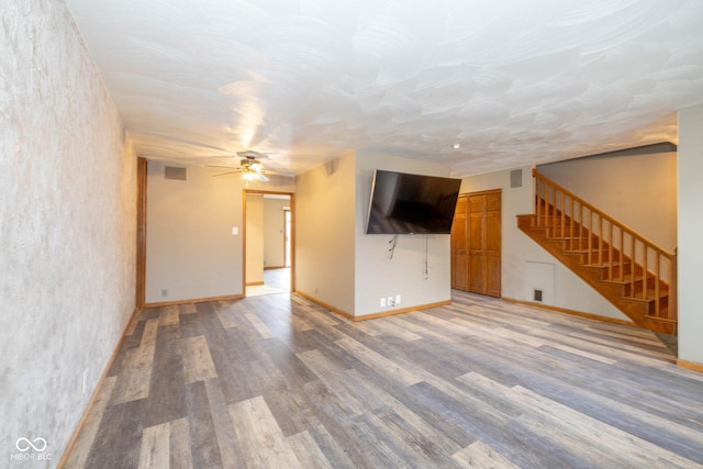 unfurnished living room featuring wood-type flooring and ceiling fan