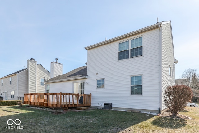 rear view of property featuring a yard and a deck