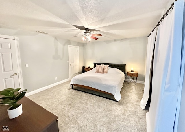 carpeted bedroom featuring a textured ceiling and ceiling fan