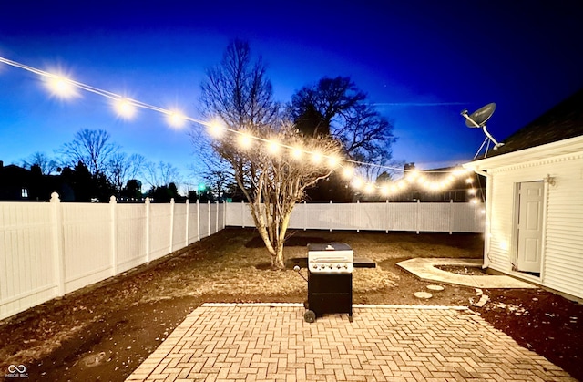 patio terrace at dusk featuring area for grilling