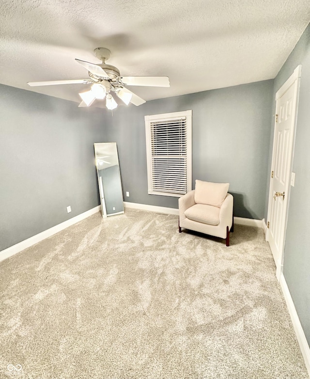 unfurnished room featuring ceiling fan, light carpet, and a textured ceiling