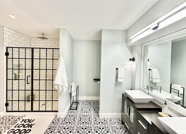 bathroom featuring vanity, an enclosed shower, and a textured ceiling