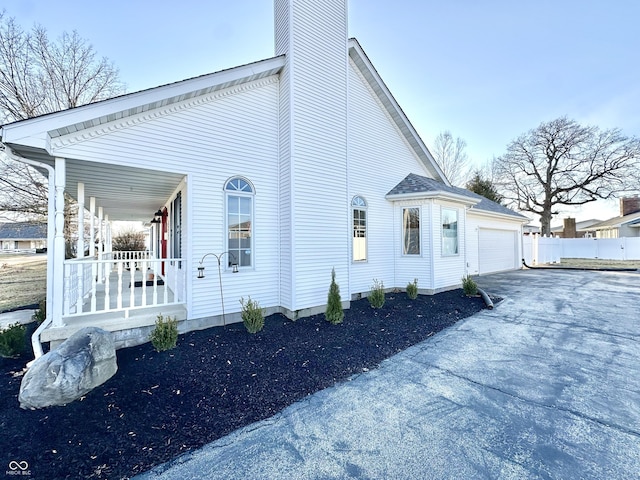 view of property exterior featuring a porch and a garage