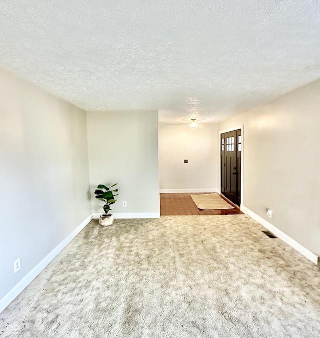 unfurnished room with a textured ceiling and carpet