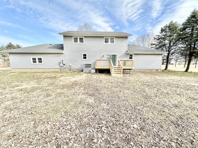 rear view of property featuring central AC unit, a yard, and a deck