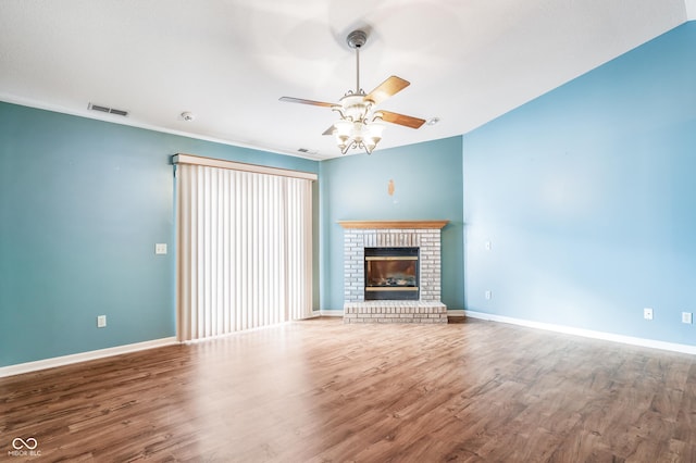 unfurnished living room with hardwood / wood-style flooring, ceiling fan, and a fireplace