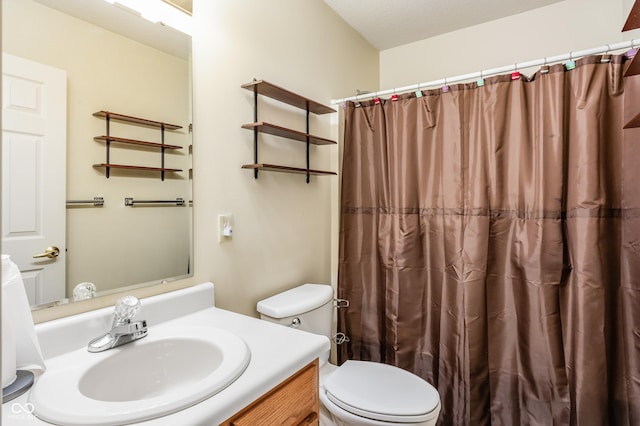 bathroom featuring toilet, vanity, and walk in shower